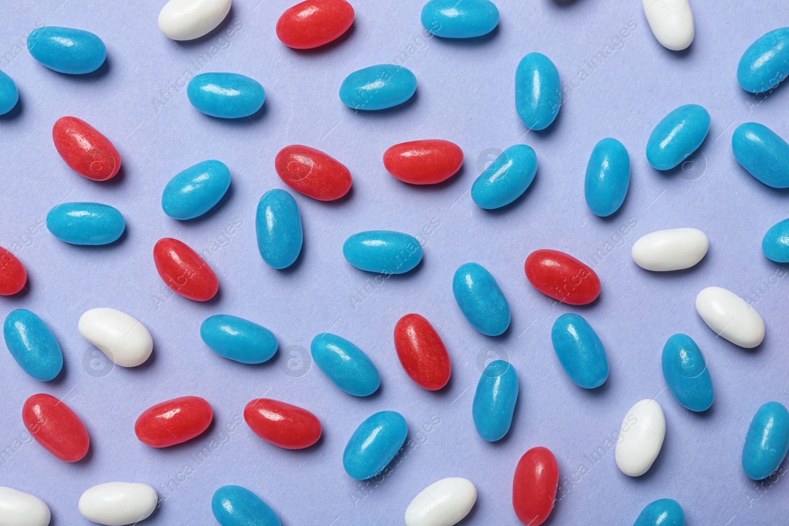 Photo of Many delicious jelly beans on color background, flat lay