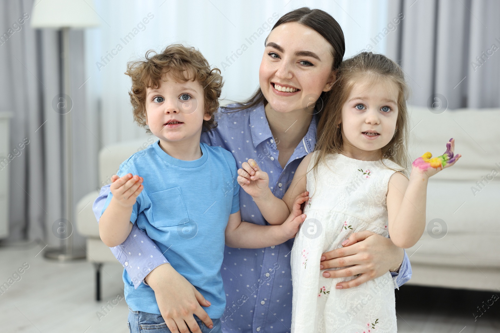 Photo of Mother and her little children with painted hands at home