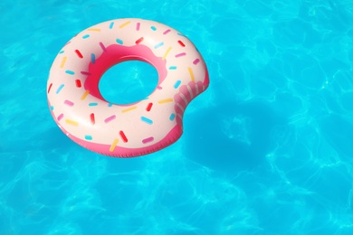 Photo of Inflatable ring floating in swimming pool on sunny day. Space for text