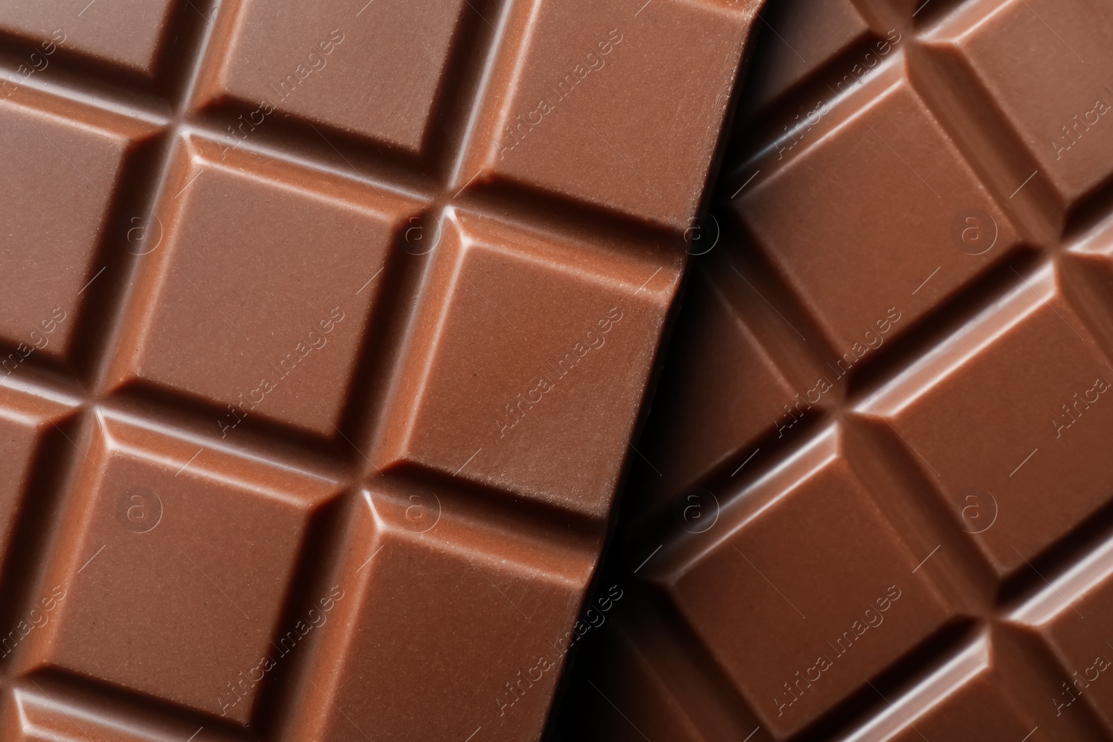 Photo of Delicious milk chocolate bars as background, top view