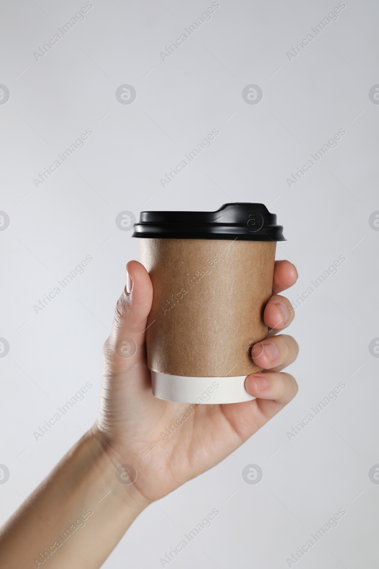 Photo of Woman holding takeaway paper coffee cup on white background, closeup