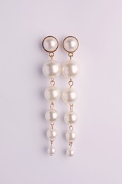 Photo of Elegant pearl earrings isolated on white, top view