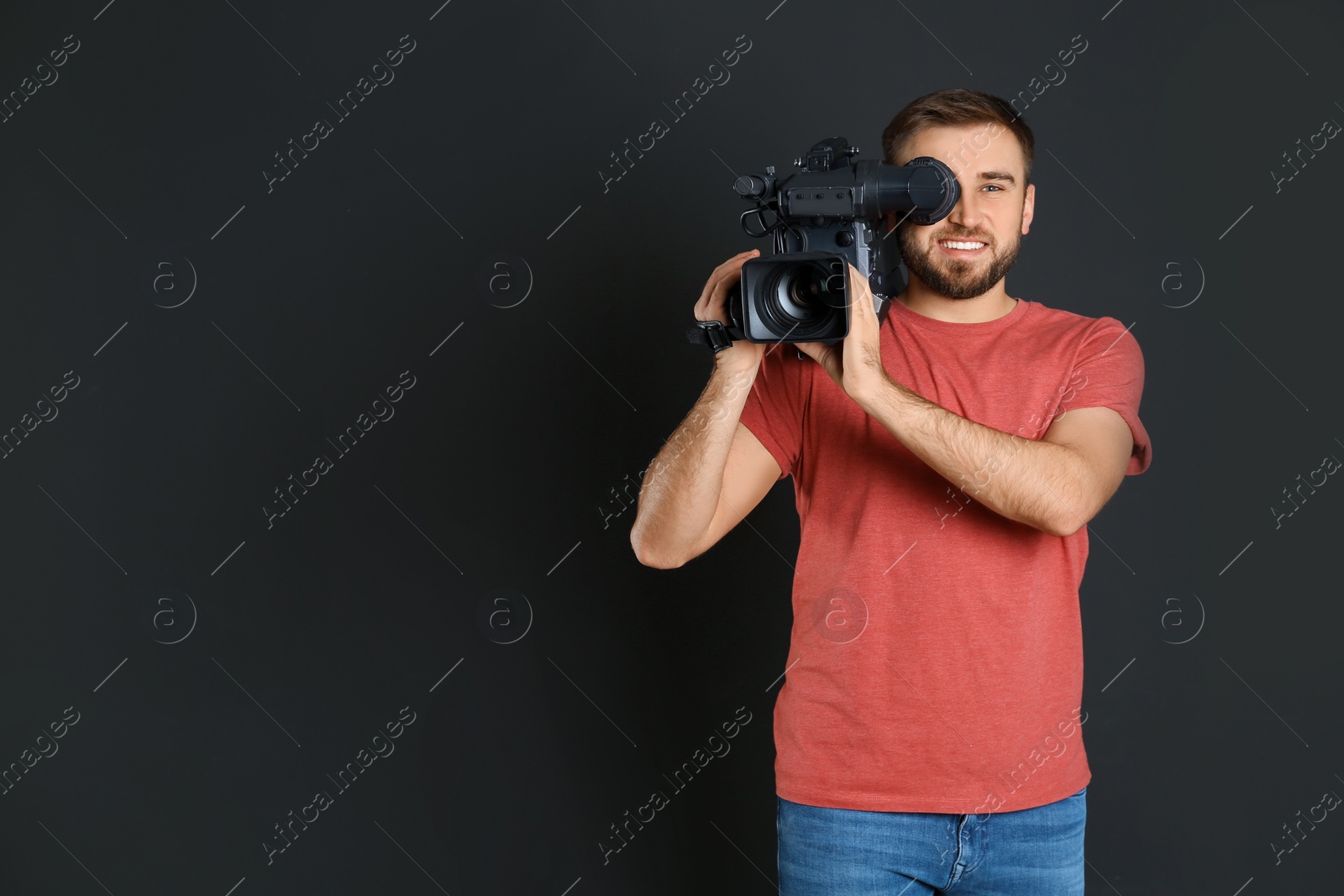 Photo of Operator with professional video camera on black background, space for text