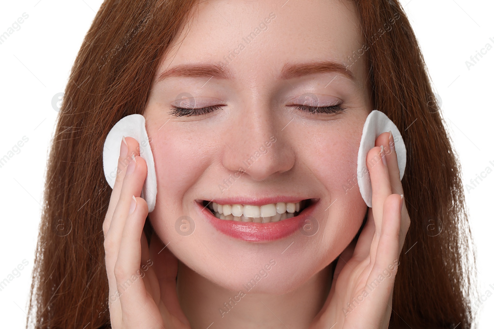 Photo of Smiling woman with freckles wiping face on white background, closeup