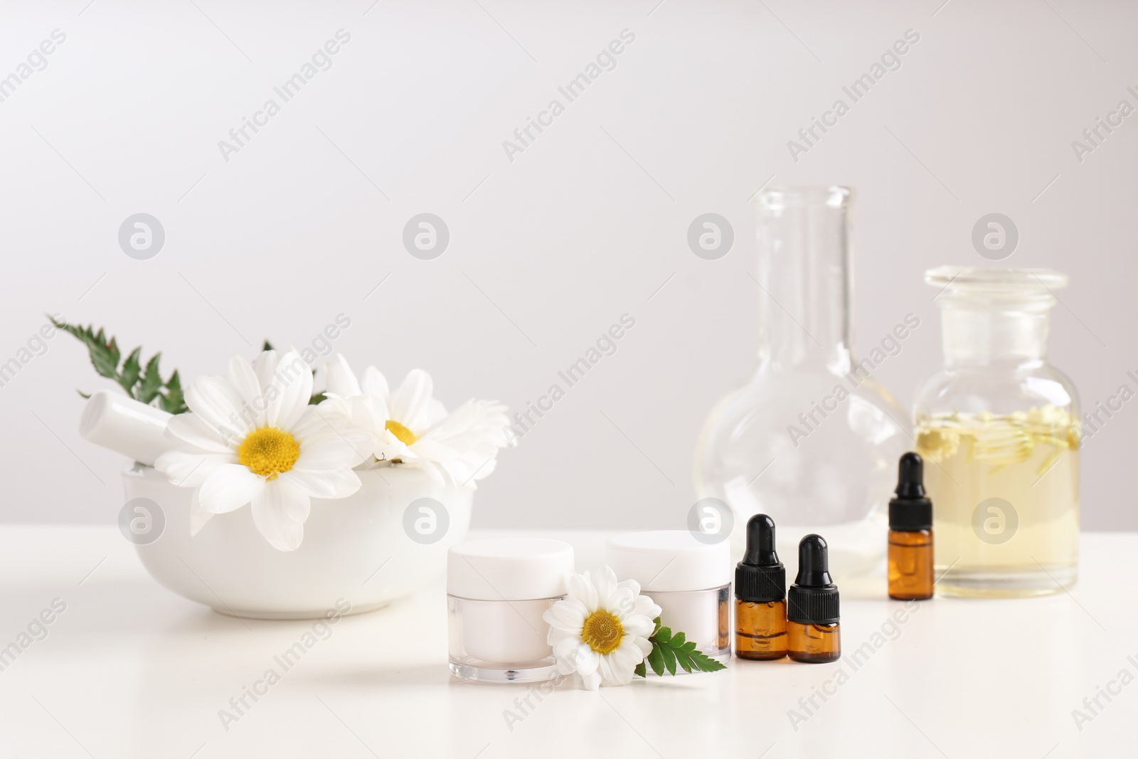 Photo of Skin care products, ingredients and laboratory glassware on table. Dermatology research