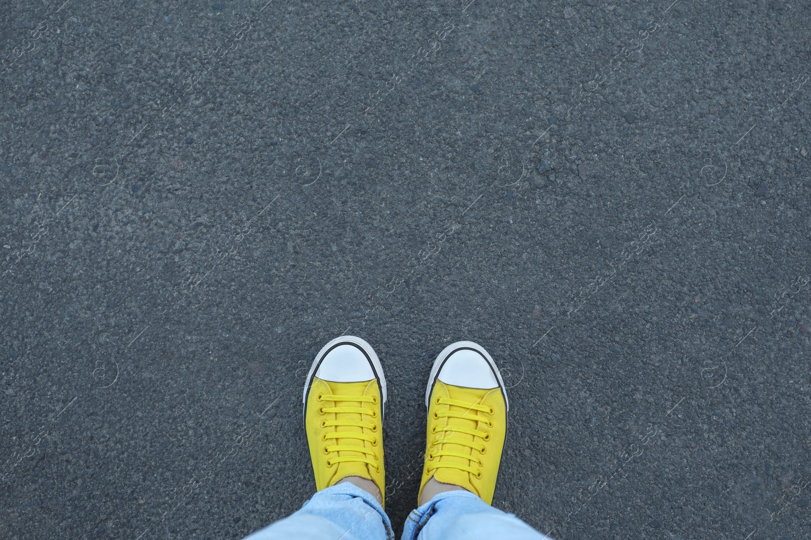 Photo of Woman standing on asphalt, top view. Space for text