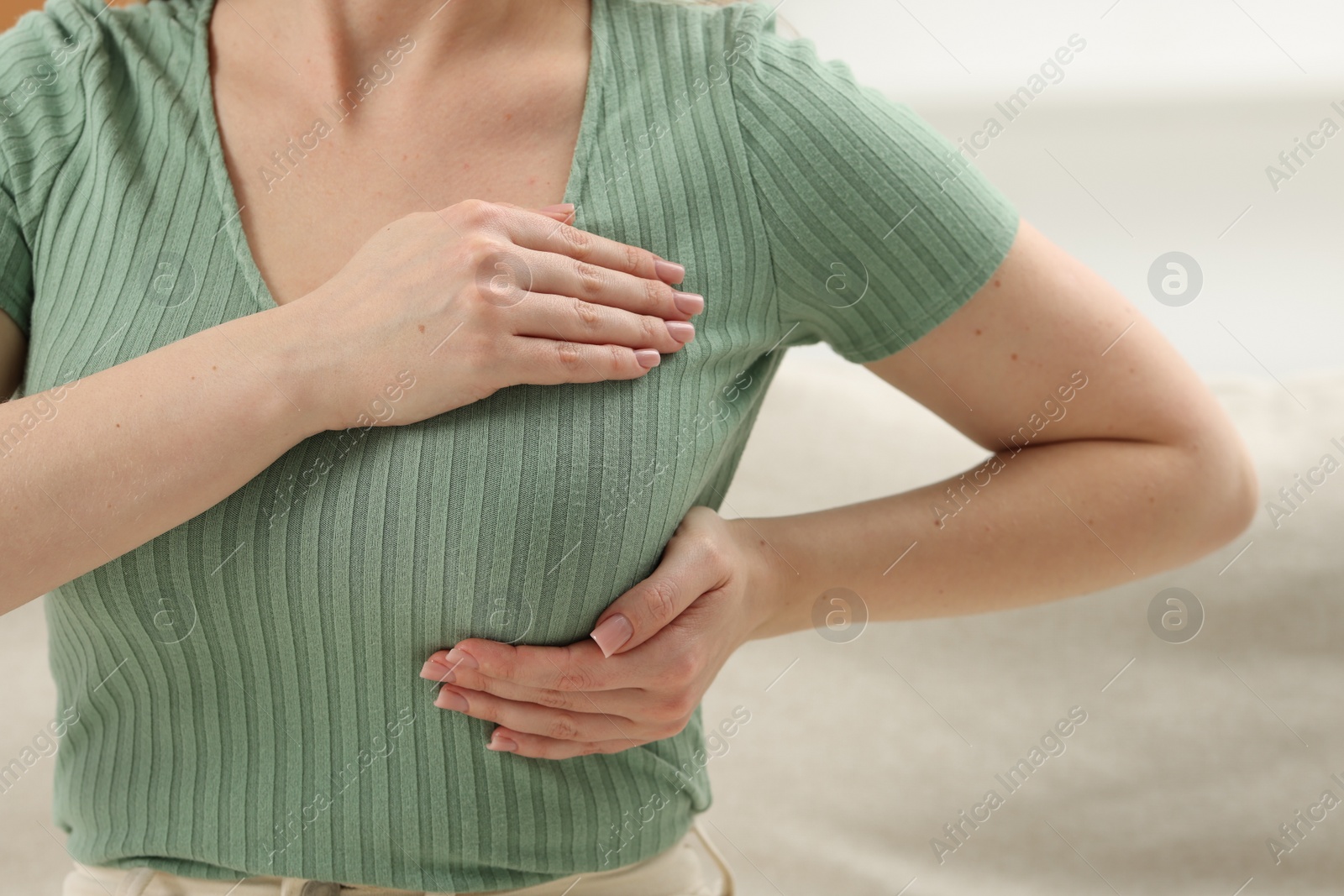 Photo of Mammology. Young woman doing breast self-examination at home, closeup