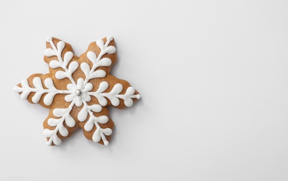 Photo of Christmas snowflake shaped gingerbread cookie on white background, top view
