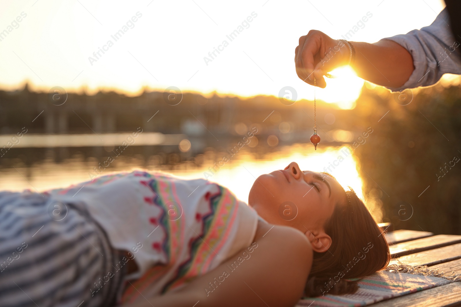 Photo of Woman at crystal healing session near river outdoors