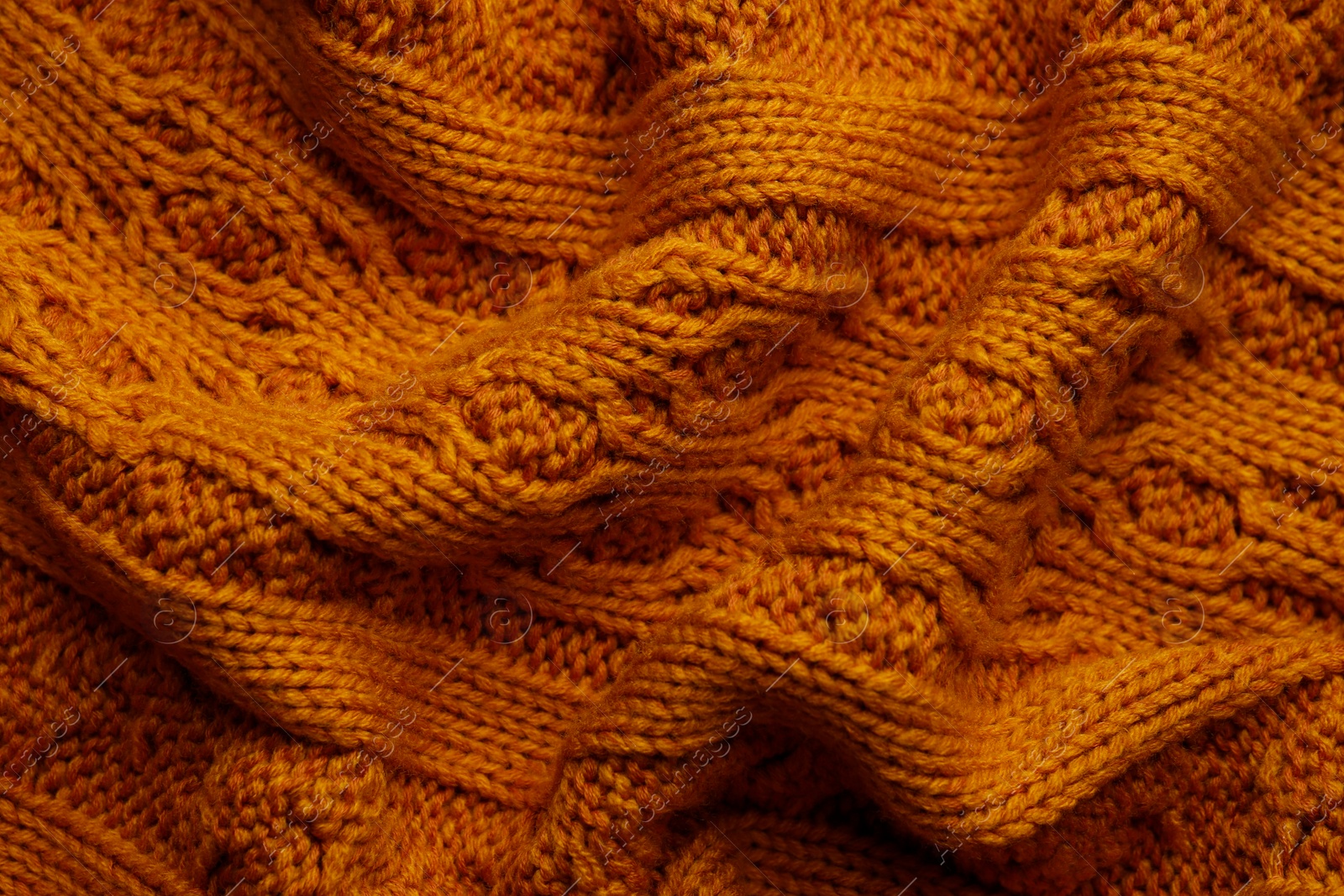 Photo of Beautiful orange knitted fabric as background, top view