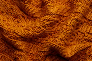 Beautiful orange knitted fabric as background, top view