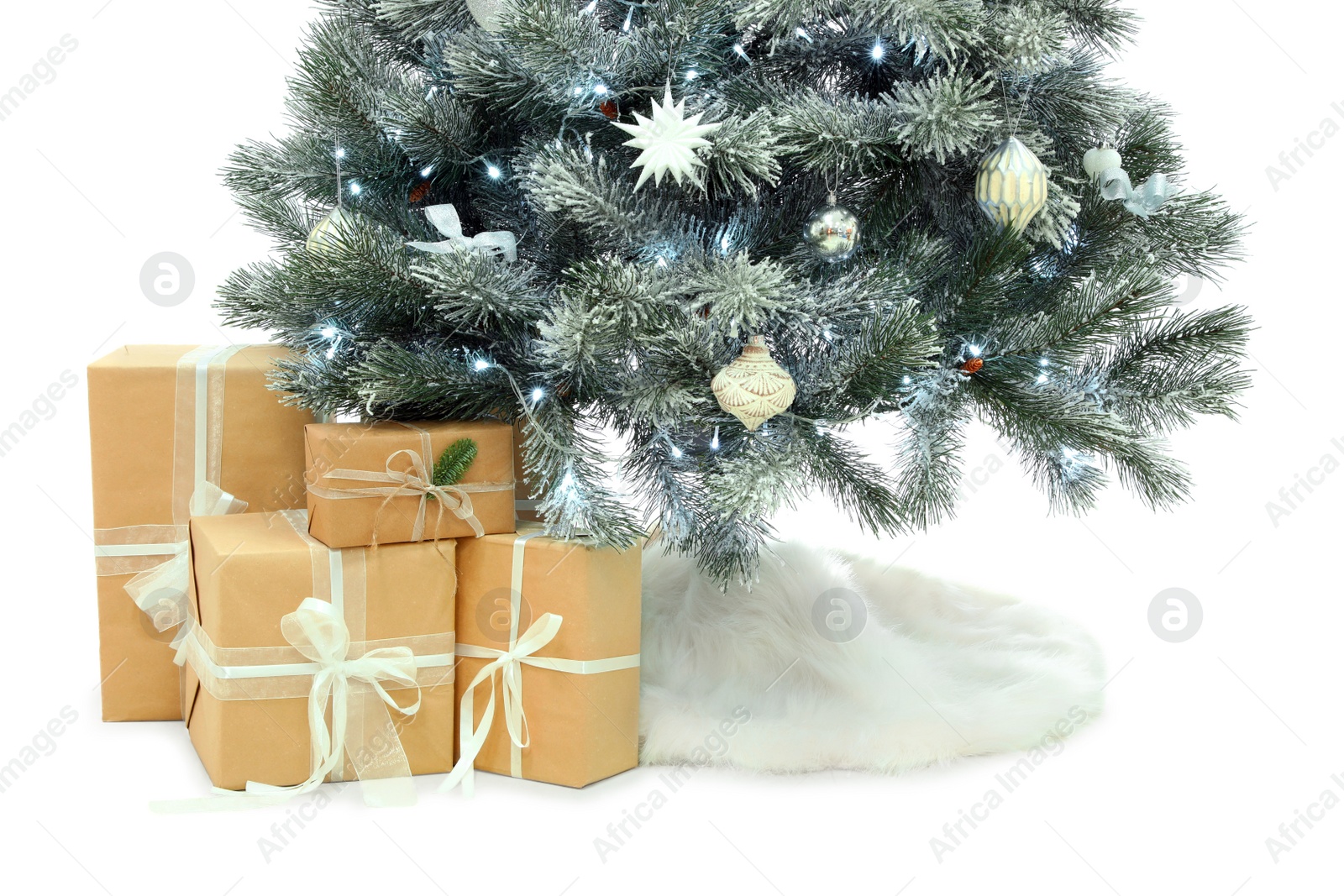 Photo of Decorated Christmas tree with faux fur skirt and gift boxes on white background