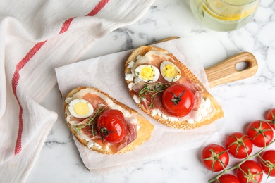 Flat lay composition with delicious bruschettas on white marble table