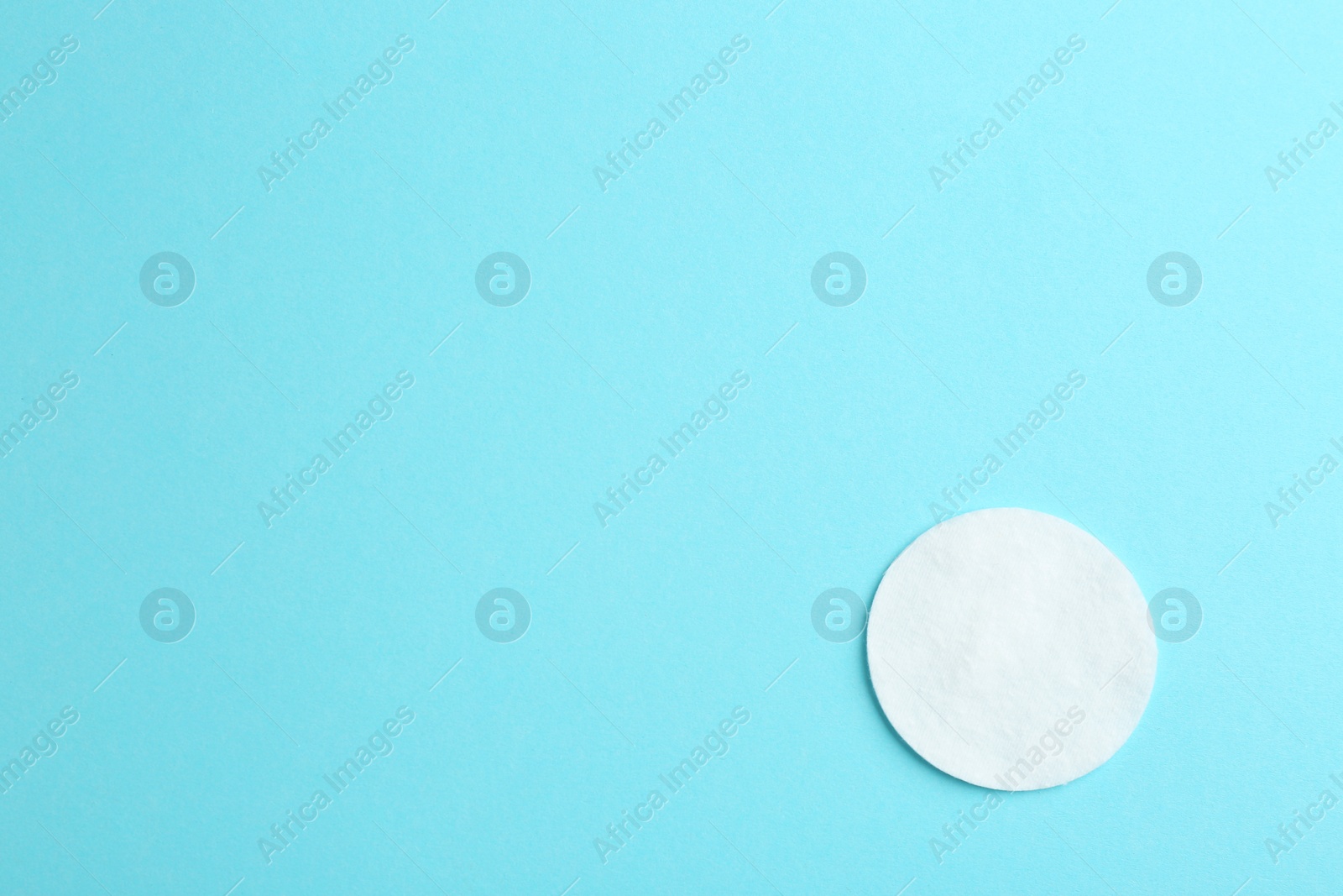 Photo of Cotton pad on color background, top view. Space for text