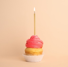 Photo of Birthday cupcake with candle on beige background