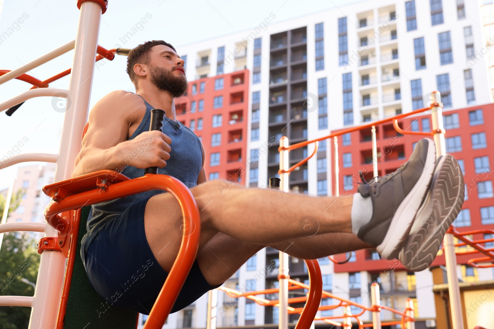 Photo of Man training on abs station, low angle view. Outdoor gym