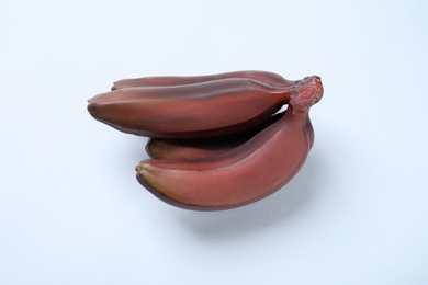 Tasty red baby bananas on light background, top view