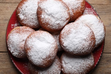 Photo of Delicious sweet buns with powdered sugar on plate, top view