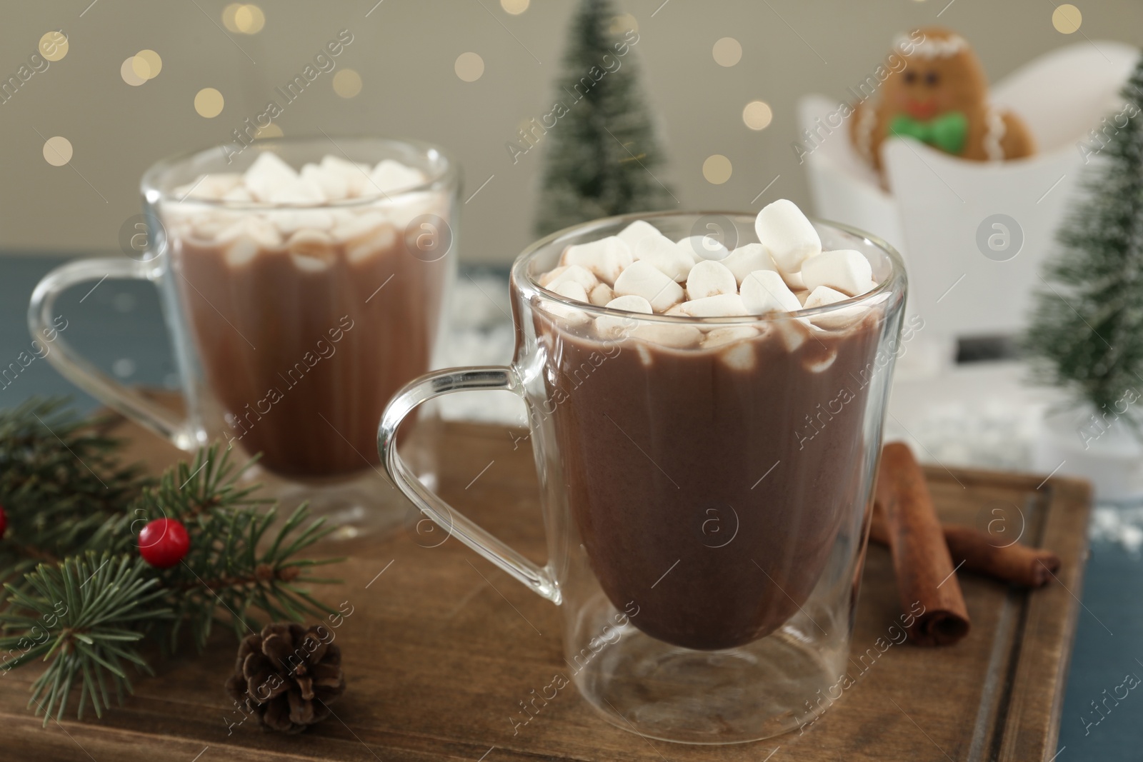 Photo of Hot drink with marshmallows in glass cup on wooden board