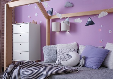 Photo of Comfortable bed in stylish child's room interior