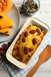 Photo of Delicious pumpkin bread with pecan nuts on light wooden table, flat lay