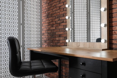 Photo of Makeup room interior with wooden table and large mirror