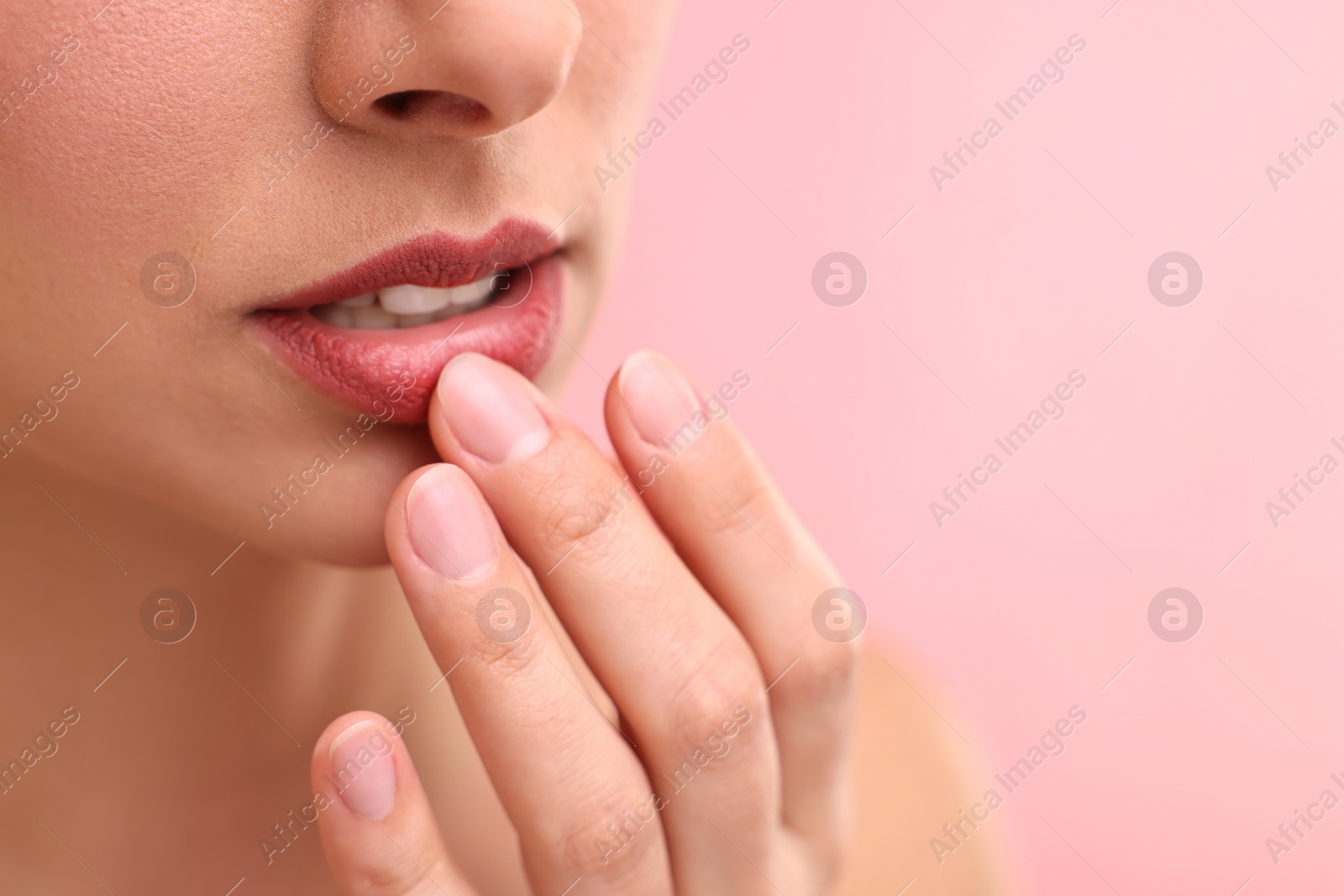 Photo of Woman with beautiful lips on pink background, closeup. Space for text