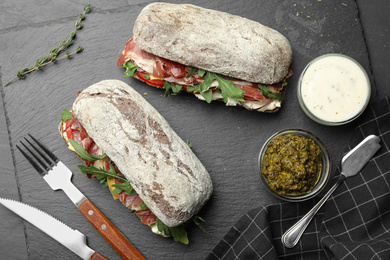 Photo of Flat lay composition with delicious sandwiches on grey table