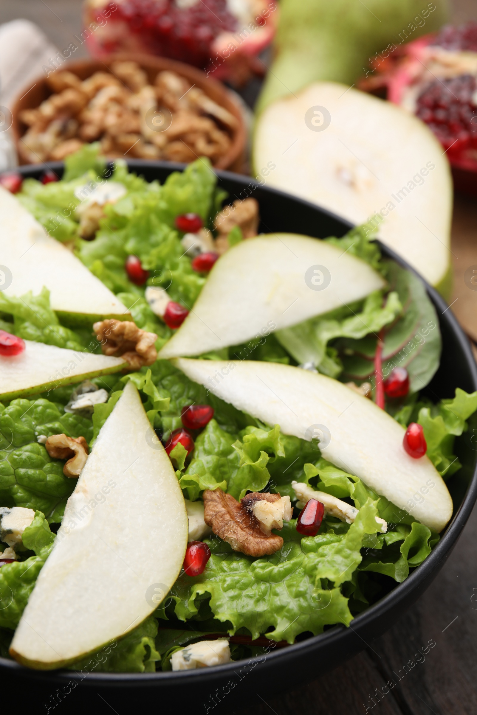 Photo of Delicious pear salad in bowl on table, closeup