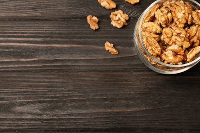 Photo of Flat lay composition with walnuts and space for text on wooden background