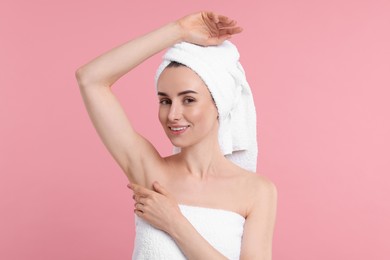 Beautiful woman showing armpit with smooth clean skin on pink background