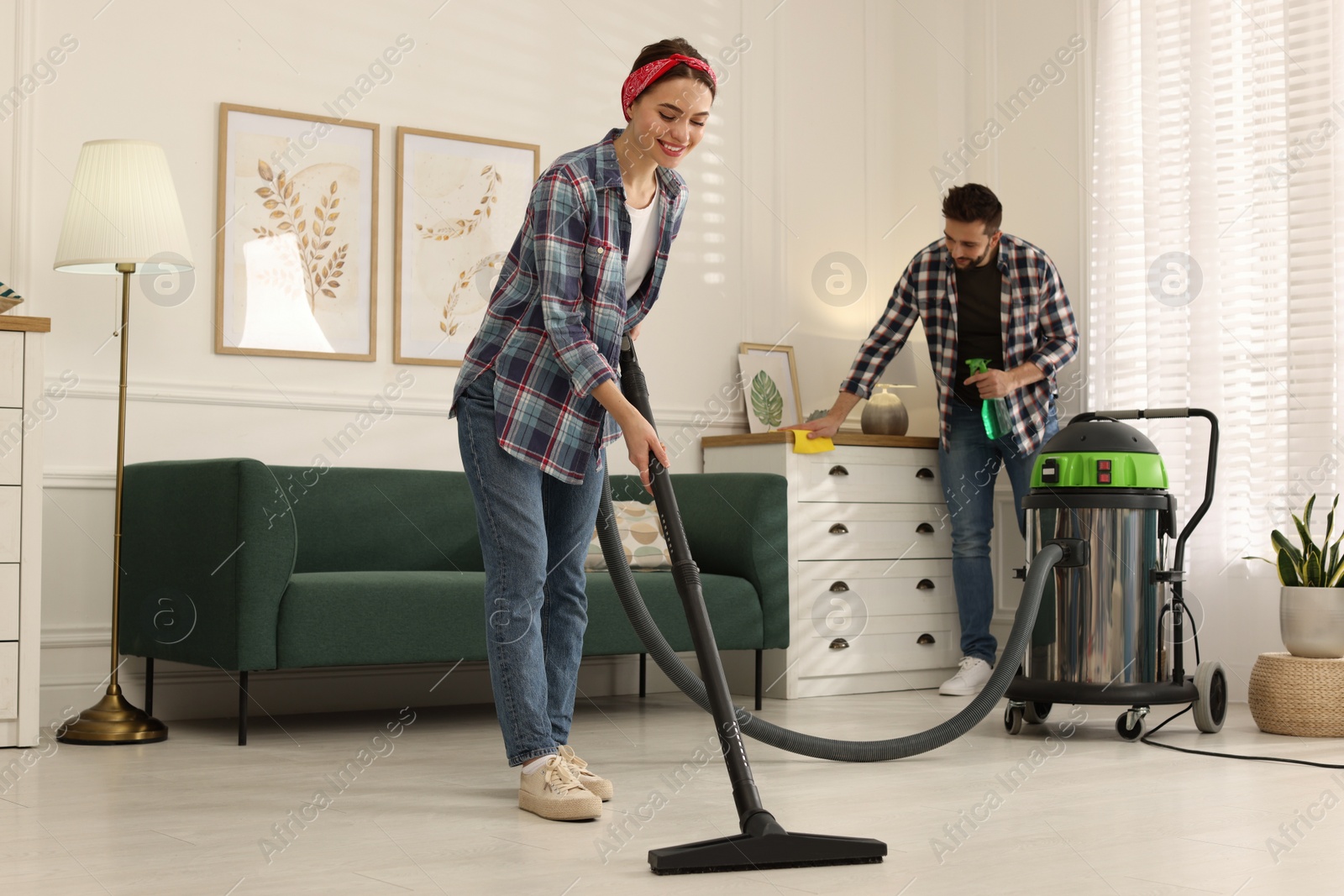 Photo of Couple cleaning up in living room together