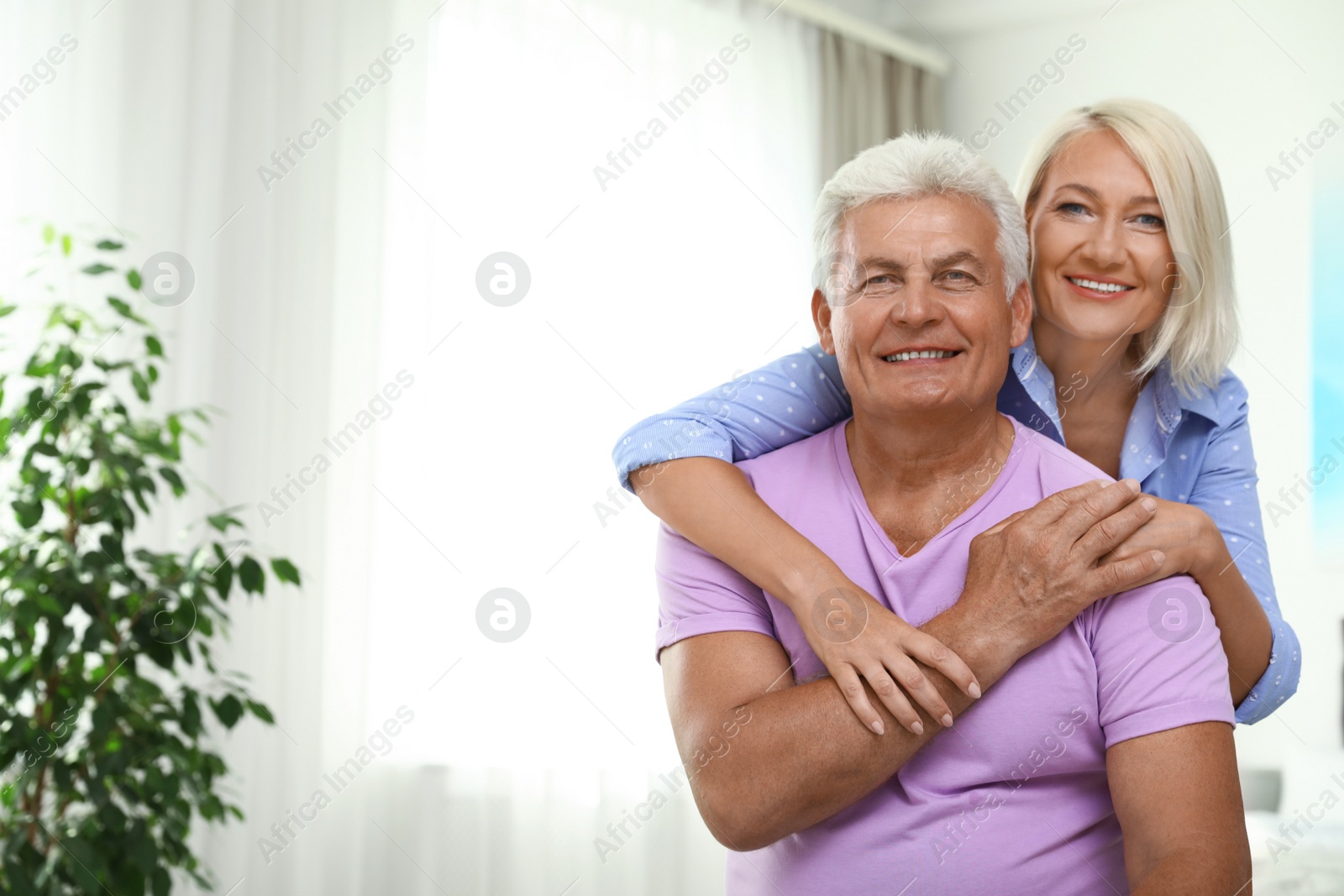 Photo of Portrait of happy senior couple at home. Space for text