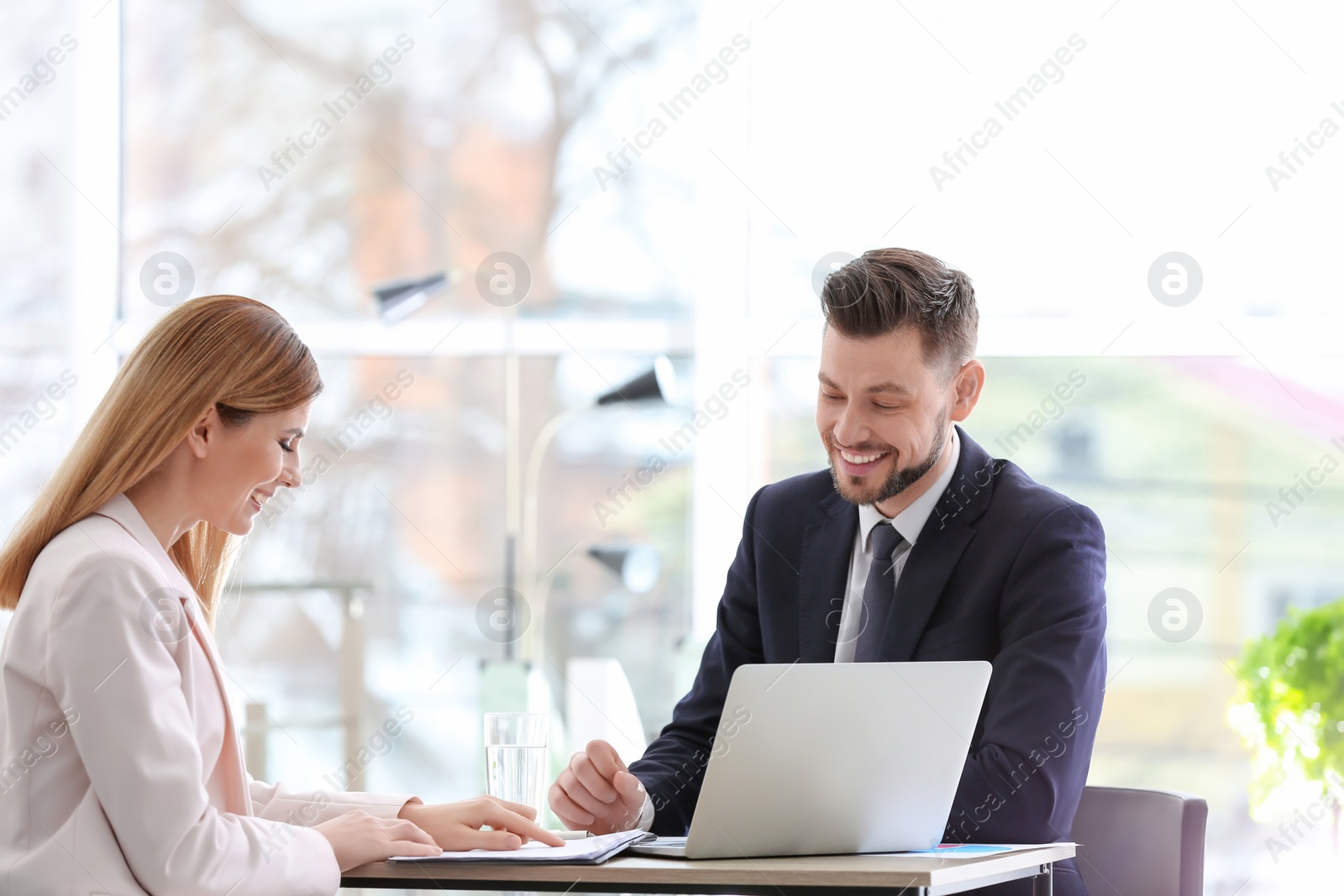 Photo of Young consultant working with client in office