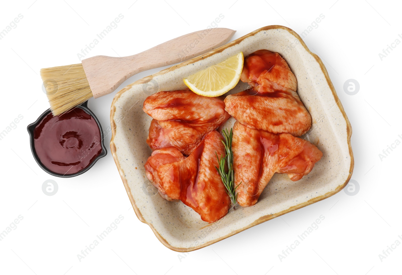 Photo of Fresh marinade, basting brush, raw chicken wings, rosemary and lemon isolated on white, top view