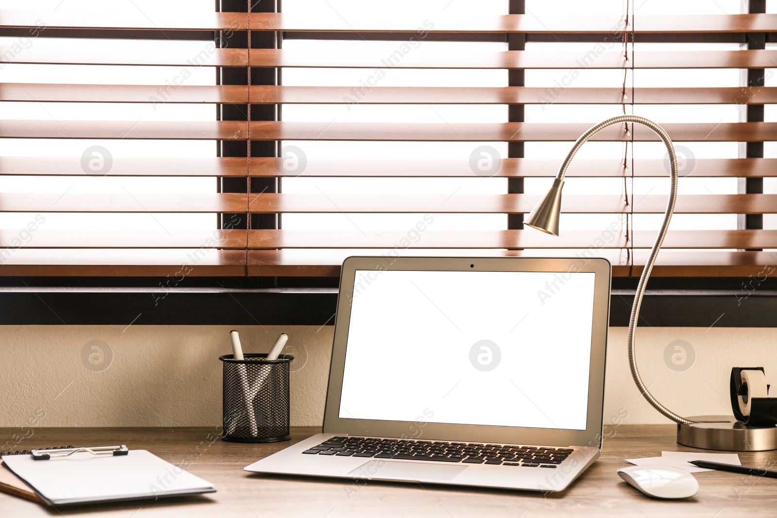 Photo of Modern laptop on table in office. Comfortable workplace