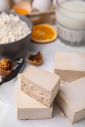 Photo of Blocks of compressed yeast and ingredients for dough on white table
