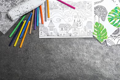 Photo of Antistress coloring pages and felt tip pens on grey table, flat lay. Space for text
