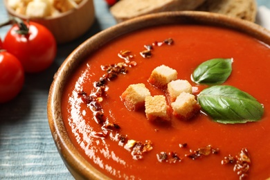 Photo of Bowl with fresh homemade tomato soup on table, closeup