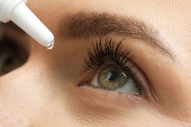 Woman applying medical eye drops, macro view