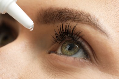 Photo of Woman applying medical eye drops, macro view