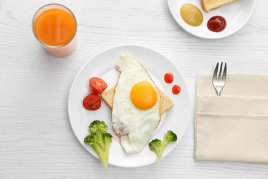 Tasty fried eggs with vegetables and juice on white wooden table, flat lay. Delicious morning meal