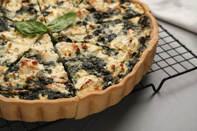 Photo of Delicious homemade spinach quiche on light gray table, closeup