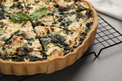 Delicious homemade spinach quiche on light gray table, closeup