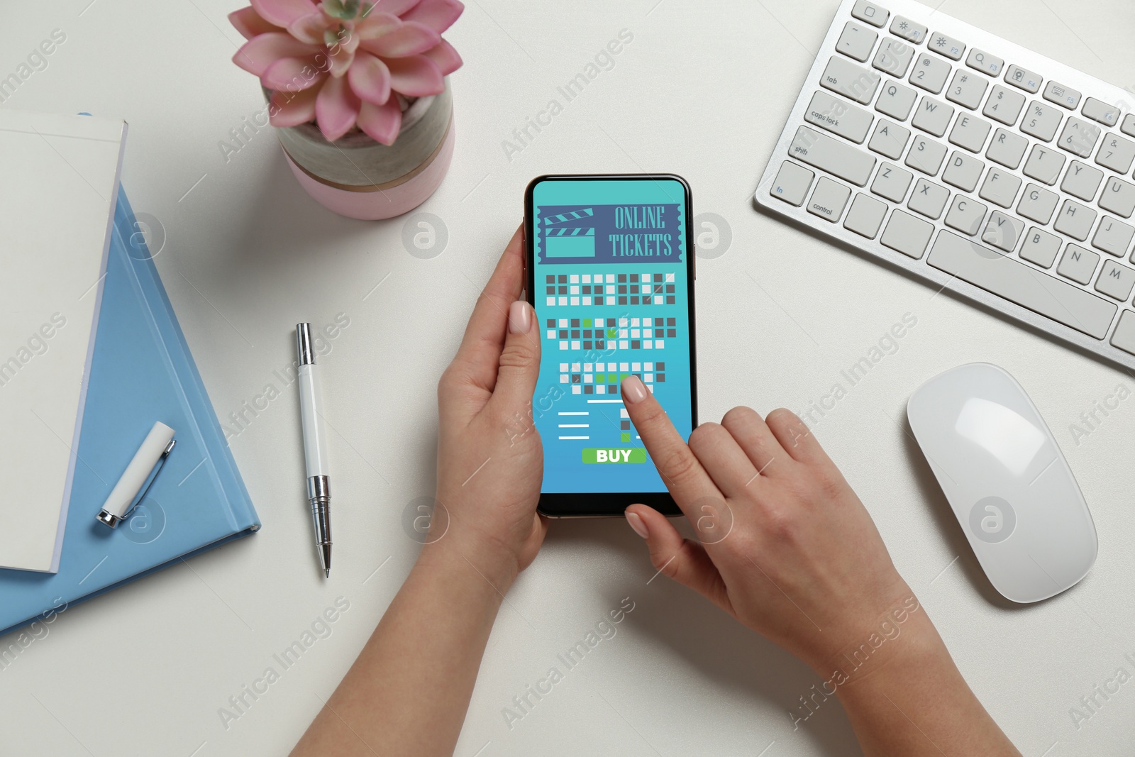 Image of Woman buying cinema tickets online via mobile phone at table, top view