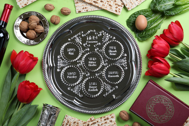 Photo of Flat lay composition with symbolic Pesach (Passover Seder) items on light green background