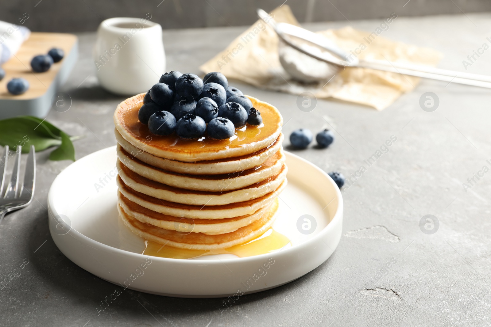 Photo of Plate with pancakes and berries on table