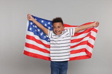 Photo of 4th of July - Independence Day of USA. Happy boy with American flag on light grey background