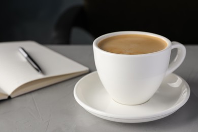 Photo of Cup of americano on light grey table in office, closeup. Coffee Break