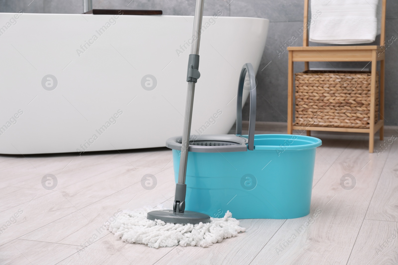 Photo of Mop and plastic bucket in bathroom. Cleaning floor